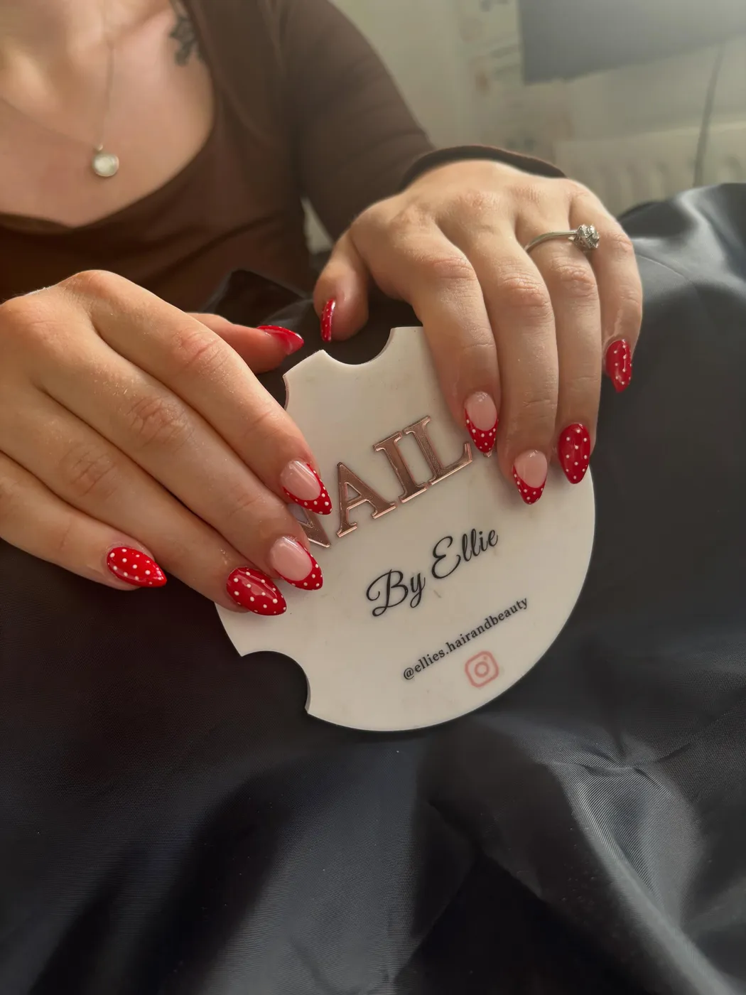 Red gel nails with white polka dot accents