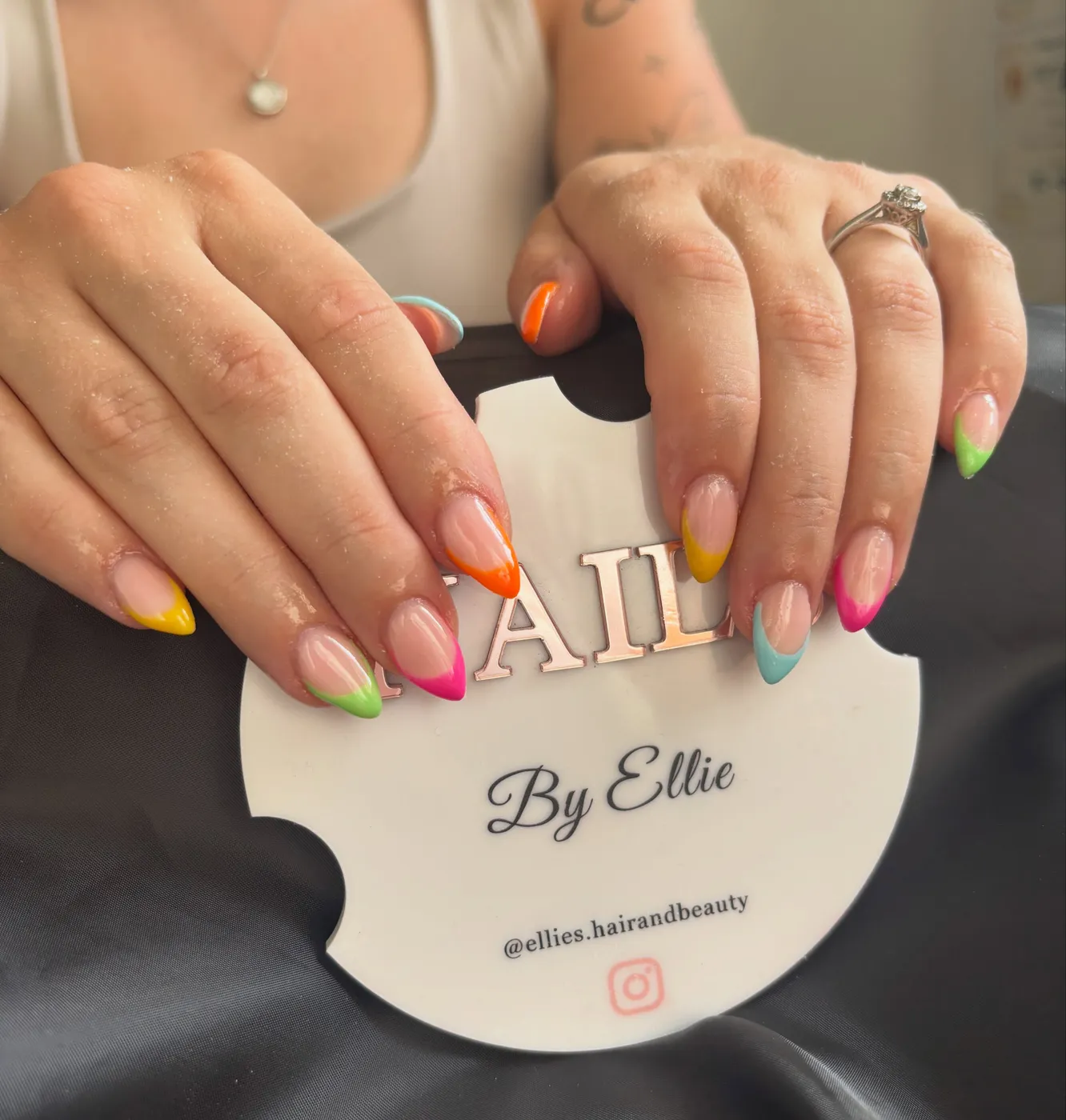 Colourful rainbow French tip nails in orange, yellow, pink and green