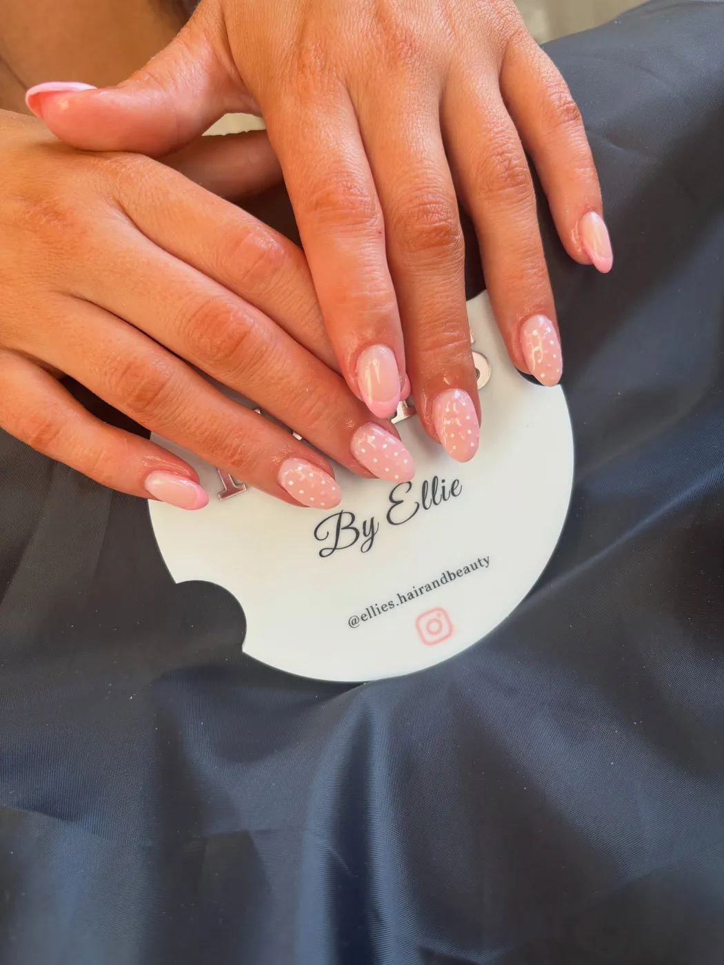 Pale pink nails with dainty white polka dots